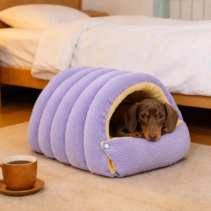 Dachshund lying in the purple cave bed next to a bed frame